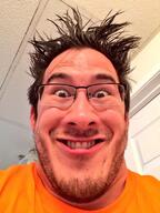 clothes glasses grin hair irl markiplier meta:variant_origin mustache orange_shirt series:irl_soyjaks smile stubble variant:markiplier_soyjak // 600x800 // 133.9KB