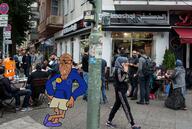 arm berlin brown_skin closed_mouth clothes euromutt full_body germany glasses hoodie irl_background muslims smile soyjak stubble subvariant:euromutt variant:markiplier_soyjak // 1900x1274 // 1.0MB