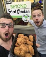 2soyjaks arm beard beyond_chicken beyond_meat brown_hair clothes ear food fried_chicken glasses hair hand holding_object irl mustache open_mouth pointing sign store stubble variant:two_pointing_soyjaks variant_origin // 1125x1374 // 158.4KB