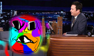 building chair color deformed distorted ear glasses glowing hair human jimmy_fallon microphone stubble subvariant:emmanuel subvariant:wholesome_soyjak suit_and_tie table talk_show the_tonight_show trend:colorjak variant:gapejak // 735x435 // 585.7KB
