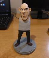 a10_eyes action_figure black_pants black_shoes blue_eyes ear figurine full_body grey_shirt jobe_smith meta:ai_generated shoe subvariant:blobson subvariant:cobson_slim subvariant:leanson table the_lawnmower_man variant:cobson white_skin // 944x1104 // 1.9MB