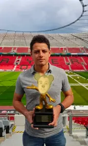 mickey mouse, 1nas, big eyes, chicharito, football, football stadium, front view, holding object with two hands, in real life, irl background