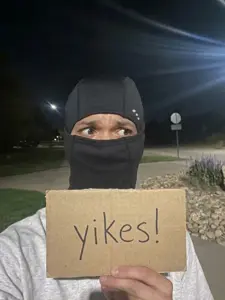 front view, holding object, holding sign, irl background, irl photo, looking to the right, mask, mouth covered, open eyes, paper